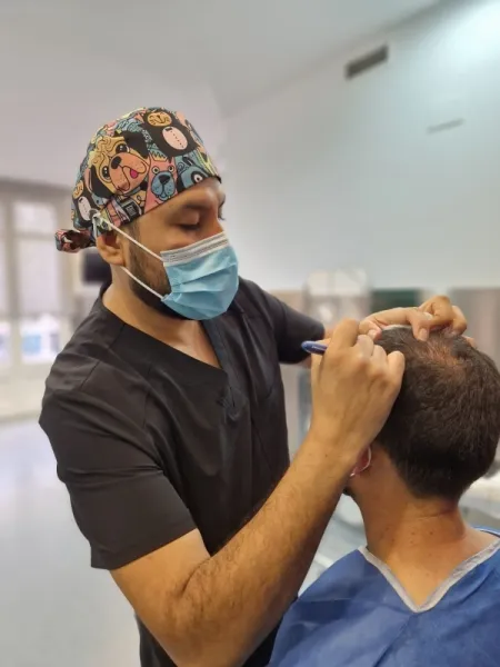 Doctor de la clinica capilar Kuntur Clinic realiza tratamiento de mesoterapia con farmacos a paciente en Barcelona